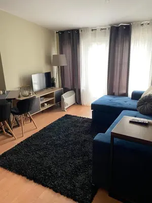 a living room with a blue couch and a table at Studio Deluxe Mian in Beli Iskar
