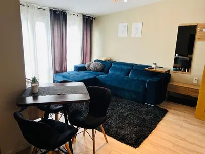 a living room with a blue couch and a table at Studio Deluxe Mian in Beli Iskar