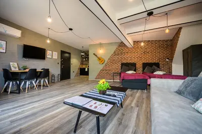 a living room with a couch and a brick wall at Urban Music Studio byPMM in Plovdiv