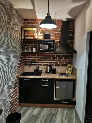 a kitchen with a sink and a brick wall at Urban Music Studio byPMM in Plovdiv