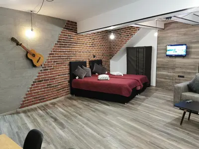 a bedroom with a red bed and a brick wall at Urban Music Studio byPMM in Plovdiv