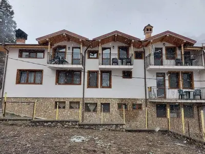 a large white building with a lot of windows at Къща за гости Камината in Trigrad