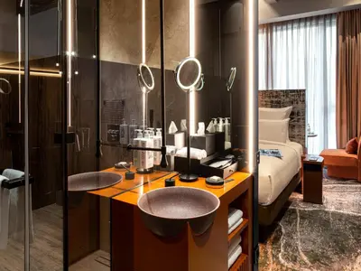 a hotel room with a bathroom with a sink and a bed at The Emporium Hotel Plovdiv - MGallery Collection in Plovdiv