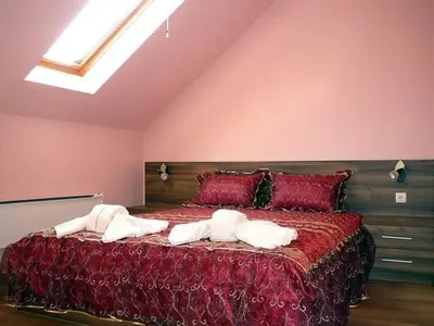 a bedroom with a large bed with towels on it at Tzvetelina Palace Hotel in Dolna Banya