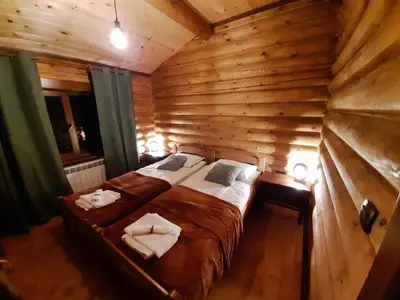 a bedroom with a bed in a wooden room at къщи за гости Под звездите in Pamporovo