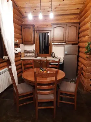 a kitchen with a table and chairs in a room at къщи за гости Под звездите in Pamporovo