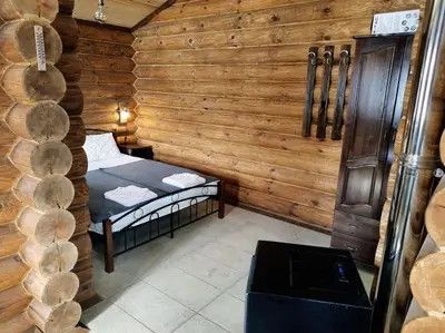 a small room with a bed in a log cabin at къщи за гости Под звездите in Pamporovo
