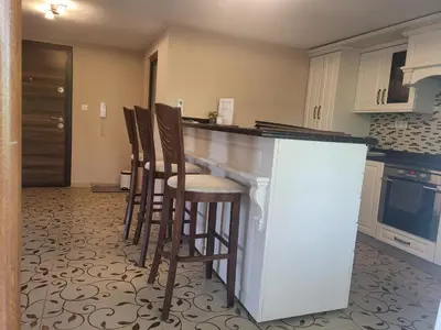 a kitchen with a bar with stools in it at Студио Лидия in Velingrad