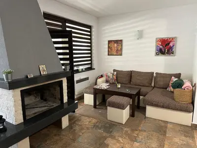 a living room with a couch and a fireplace at Марковската къща in Oreshak