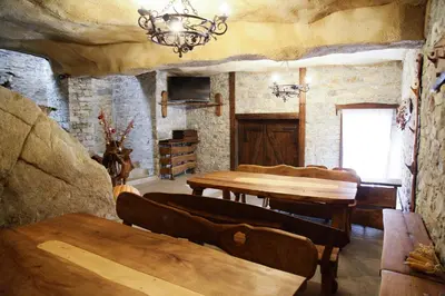 a living room with a table and chairs and a chandelier at Galabova Guesthouse in Delchevo