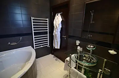 a bathroom with a tub and a glass sink at Villa Vuchev in Velingrad