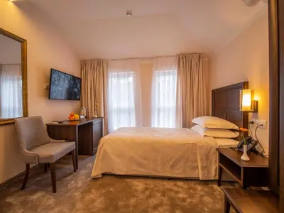 a bedroom with a bed and a chair and a mirror at The Moon Boutique Hotel in Sofia