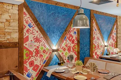 a dining room with a table and a colorful wall at 103 Alpine Hotel in Panichishte