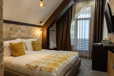a hotel room with a bed and a large window at 103 Alpine Hotel in Panichishte