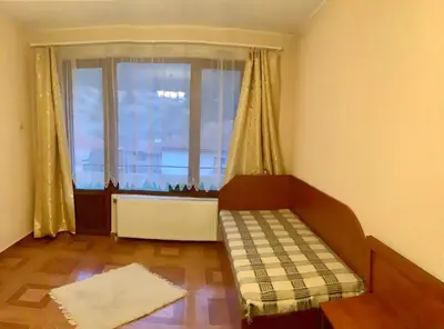 a living room with a couch and a large window at Приключение в Триград in Trigrad