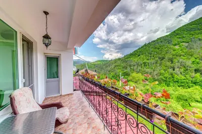 a balcony with a view of a mountain at Къща за гости Хаджиевата къща in Smolyan