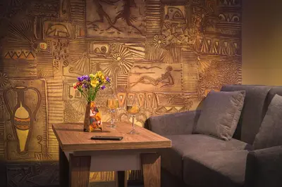 a living room with a couch and a table with wine glasses at АРТ СТУДИО СОФИЯ in Sofia