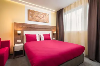 a bedroom with a large pink bed with a window at АРТ СТУДИО СОФИЯ in Sofia