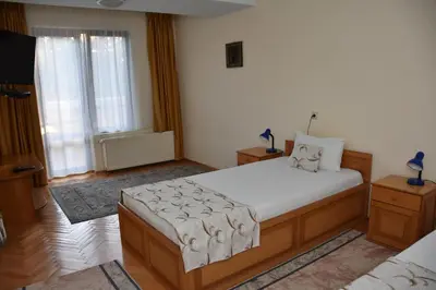 a bedroom with a bed and a large window at Хотел Сима in Beklemeto