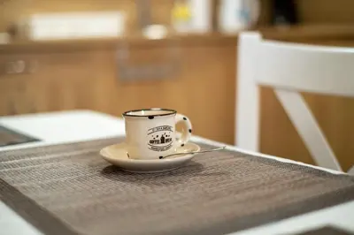 a coffee cup sitting on a plate on a table at Апартамент В4 in Velingrad