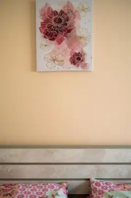 a picture of flowers on the wall above a bed at Апартамент В4 in Velingrad