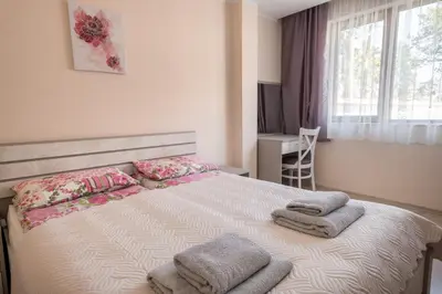 a bedroom with a large bed with towels on it at Апартамент В4 in Velingrad