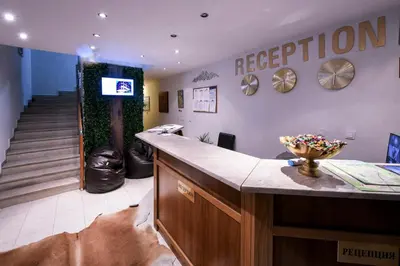 a waiting room with a reception counter and stairs at Paradise in the Mountain in Bansko