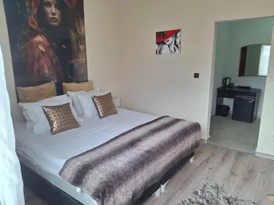 a bedroom with a bed with a painting on the wall at Paradise in the Mountain in Bansko