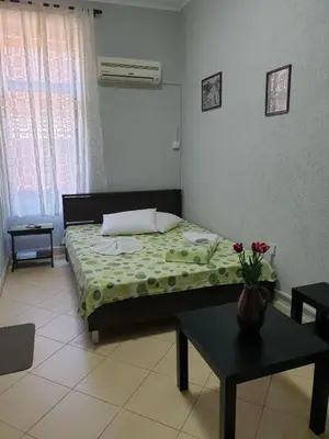 a bedroom with a bed with a vase of flowers on it at KM!Sofia - Стаи за гости in Sofia