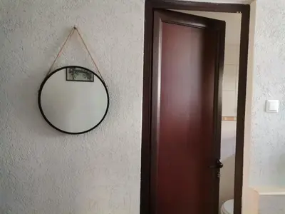 a mirror hanging on a wall next to a door at KM!Sofia - Стаи за гости in Sofia