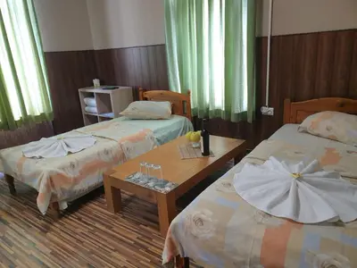 a hotel room with two beds and a table at KM!Sofia - Стаи за гости in Sofia