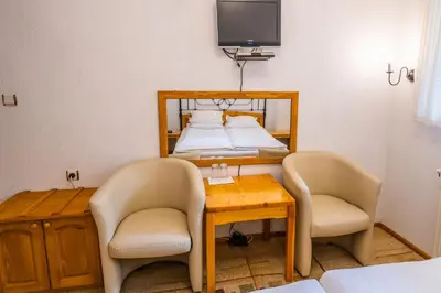 a room with a bed and two chairs and a table at Toni's Guest House in Melnik