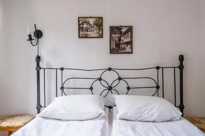 two beds with white sheets and pillows in a bedroom at Toni's Guest House in Melnik