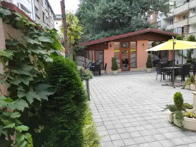 a patio with tables and chairs and an umbrella at Hotel House K21 in Sofia