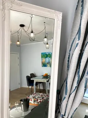 a mirror in a room with a table and a dining room at Diva Garden Apartment in Plovdiv