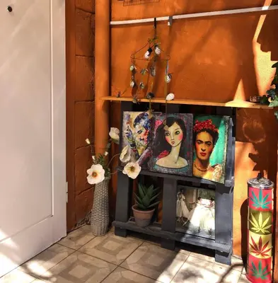 a room with paintings and flowers on a shelf at Diva Garden Apartment in Plovdiv
