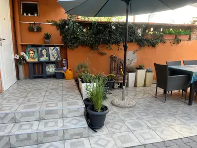 a patio with a table and an umbrella and plants at Diva Garden Apartment in Plovdiv