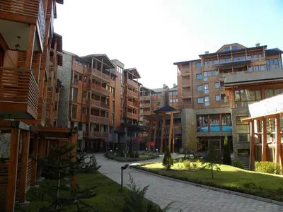 a city street with tall buildings and a sidewalk at Saint Ivan Ski Apartments in Bansko