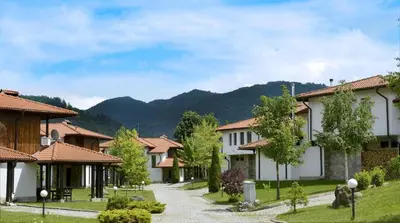 a row of houses with mountains in the background at Къща за гости Volpe - Volpe Guesthouse in Oreshak