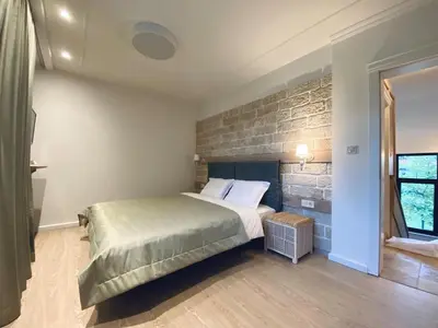 a bedroom with a bed and a brick wall at Къща за гости Volpe - Volpe Guesthouse in Oreshak