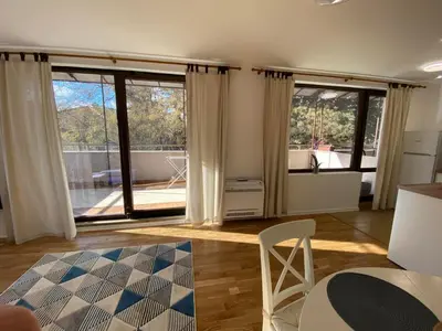 a living room with large windows and a kitchen at Bendida Central in Velingrad