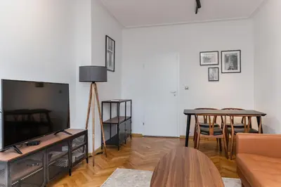 a living room with a couch and a tv and a table at Industrial 2-BDR Flat by the National Stadium by Flat Mаnager in Sofia