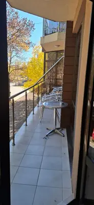 a balcony with a table on the side of a building at Fantasy Apartaments and studios Avenue комплекс Фантазия Хисаря in Hisarya