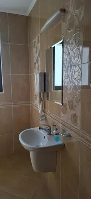 a bathroom with a sink and a mirror at Fantasy Apartaments and studios Avenue комплекс Фантазия Хисаря in Hisarya