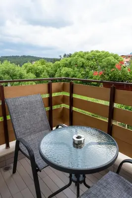 a table and chairs on a balcony with a view at Villa Pino in Velingrad