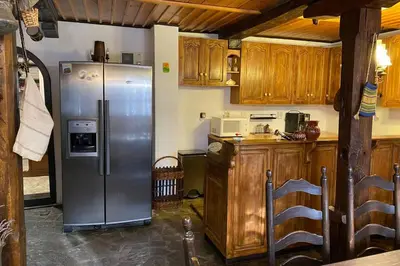 a kitchen with a stainless steel refrigerator and wooden cabinets at Guest House 