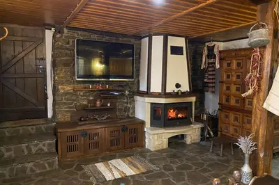 a living room with a stone fireplace and a television at Guest House 