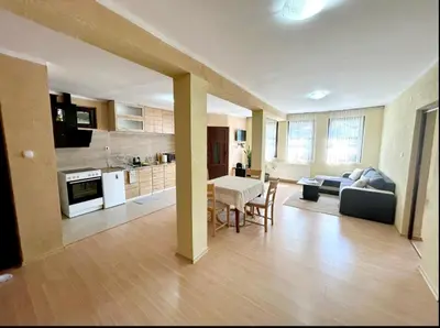 a kitchen and living room with a table and a couch at Авина къща in Kovachevitsa