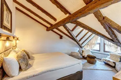 a bedroom with a bed in a room with wooden ceilings at Българче Хотел - Ресторант in Smolyan