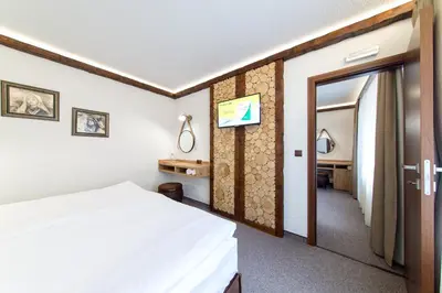 a hotel room with a bed and a mirror at Българче Хотел - Ресторант in Smolyan